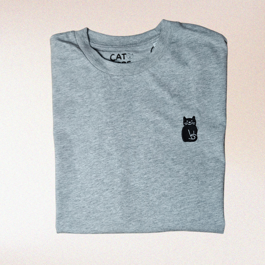 Detail van zwarte kat borduursel op lichtgrijze katoenen t-shirt.