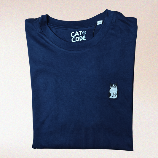 Donkerblauwe t-shirt met geborduurde tuxedo kat, tegen roze achtergrond.