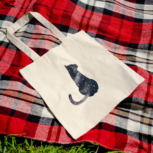 Totebag met een zwarte kat omringd door sterretjes, magisch en minimalistisch

